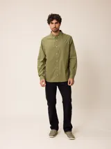 Camisa de manga larga en color blanco, confeccionada en algodón. Presenta cuello abotonado, cierre frontal con botones y un bolsillo en el pecho.