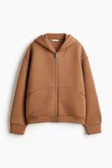 Campera con capucha forrada, confeccionada en tejido efecto neopreno color tostado. Presenta hombros caídos, cierre frontal, costuras visibles delanteras, bolsillos laterales discretos y terminaciones en rib en puños y bajo.