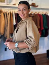 Camisa de algodón color beige, con cuello clásico, mangas largas con puños ajustables y corte holgado.