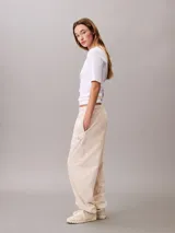 Pantalón tipo jogger de Calvin Klein en color beige, confeccionado en tejido de felpa de mezcla de algodón. Presenta cintura elástica con cordón ajustable, bolsillos laterales y bajos con puños de canalé. Incluye un discreto monograma de la marca estampado en la pierna.