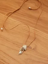 Collar con dije de medusa en metal dorado y cordón de hilo color tostado ajustable.