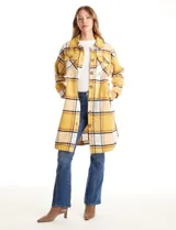 Sobrecamisa larga de tejido soft con estampado de cuadros en tonos celestes, beige y blanco. Presenta cuello con solapa, cierre frontal con botones, bolsillos aplicados en el pecho y mangas largas con puños abotonados.