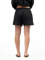 Short de lino color negro, con cintura elástica y bolsillos laterales, de diseño holgado y cómodo.