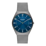 Reloj analógico de cuarzo con caja de acero inoxidable en tono gris carbón y malla metálica tipo milanesa. Presenta una esfera azul con acabado sunray, números arábigos y dos agujas.