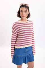 Sweater de tejido de punto fantasía a rayas horizontales en color crudo y fucsia, de manga larga y cuello redondo.