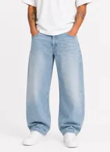 Jean de denim celeste claro, corte oversize tipo barrel con silueta curva y amplia caída hacia los tobillos, con diseño clásico de cinco bolsillos y trabillas para cinturón.