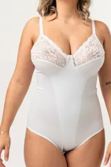 Body modelador blanco de alta contención, sin aro, con breteles elásticos regulables y broches en la entrepierna. Presenta encaje floral en la parte superior del busto y fundillo de algodón.