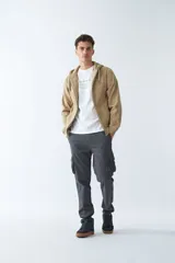 Campera de felpa color blanco hueso, con capucha y cordón ajustable, cierre frontal con cremallera, bolsillos laterales, logo y arte estampado en el pecho.