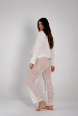 Pantalón largo de tejido calado en color blanco, con diseño de diversos puntos abiertos y corte recto levemente acampanado.