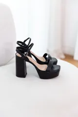 Sandalias de plataforma con taco ancho y alto, color dorado metálico. Poseen una tira ancha en la parte delantera del pie y una tira fina ajustable con hebilla en el tobillo.