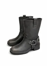 Botas estilo biker de caña media en color gris oscuro con efecto desgastado. Presentan una tira decorativa con hebilla metálica y herrajes plateados en el tobillo, además de una suela de goma con tacón bajo.