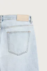 Pantalón de jean corte recto desde la cadera hasta el tobillo, con tiro medio y tejido rígido. Presenta diseño de cinco bolsillos, cierre frontal con botones y acabado en efecto lavado claro.