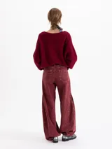 Pantalon wide leg de tiro medio confeccionado en denim con lavado efecto gastado. Presenta pierna amplia, cinco bolsillos, cierre frontal con botón y cinturón integrado del mismo tejido con doble hebilla metálica.