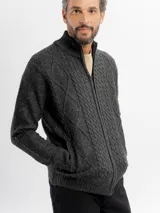 Campera tejida con cierre frontal completo, cuello alto y diseño de trenzas y rombos en el frente. Cuenta con bolsillos laterales y puños y ruedo acanalados.