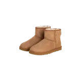 Botas de caña baja tipo Ugg en color marrón tostado, confeccionadas en gamuza con forro interior de piel sintética visible en el borde superior. Presentan suela plana de goma tono sobre tono.