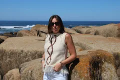 Chaleco tejido a mano en lana merino color crudo con diseño calado y flecos en el ruedo.