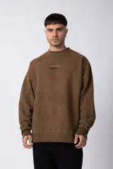 Buzo de cuello redondo en algodón rústico con efecto de lavado gastado, corte oversize y estampa frontal pequeña con texto.