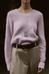 Jersey de punto con textura efecto cepillado, cuello en V y manga larga con terminaciones en rib.