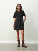 Vestido corto negro con corte evasé, mangas cortas y cuello redondo.