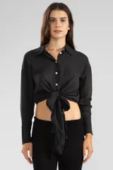 Camisa negra de manga larga con lazo en la cintura y botones nacarados.