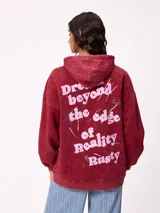 Canguro oversize color negro con efecto lavado, capucha y estampa gráfica en la espalda con tipografía desgastada y detalles en color turquesa.