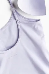 Top deportivo cropped color lila de corte ajustado, con breteles finos ajustables, escote redondo y soutien integrado con relleno extraíble. Confeccionado en tejido funcional con tecnología SoftMove y DryMove.