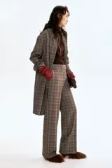 Pantalón de vestir con estampado a cuadros Príncipe de Gales en tonos marrón, negro y beige. Presenta un corte recto de pierna ancha, talle alto con pretina prolongada y cierre oculto.