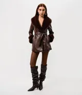 Blazer largo de cuero sintético color marrón, con cuello amplio y puños decorados con pelo sintético. Incluye un cinturón de la misma tela para ajustar en la cintura.