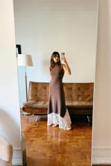 Vestido largo de cuello perkins y diseño sin mangas, confeccionado en tejido de punto color marrón. Presenta un bajo con corte evasé y detalle de encaje en color crudo a contraste. Cierre posterior con cremallera oculta.