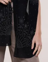 Pashmina rectangular de gasa semitransparente negra, con apliques de microstrass brillantes que forman motivos estelares. Tejido fluido de caída ligera.