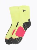 Medias técnicas de caña media, color amarillo claro con talón, puntera y refuerzo en el arco en tonos gris oscuro y fucsia. Presenta el logo de la marca impreso en negro y detalles de tejido acolchado en zonas de presión.