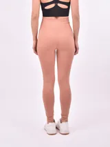 Calza larga de lycra color rosa viejo, con cintura alta y corte ajustado.