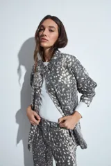 Sobrecamisa de jean con estampado animal print abstracto en tonos gris y blanco, de corte relajado, cuello camisero, cierre frontal con botones metálicos y bolsillos frontales.
