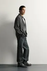 Camisa de hombre regular fit confeccionada en tejido fluido de viscosa gris, con cuello solapa, manga larga con puño abotonado y cierre frontal con botones.