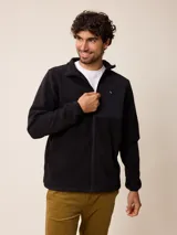 Campera de polar color beige con cierre frontal completo y cuello alto. Presenta un bolsillo en el pecho con cierre y detalle de parche con logo. El diseño combina paneles de tejido polar con detalles en tejido técnico en la zona del pecho.