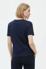 Remera de manga corta color azul marino con cuello redondo y estampado frontal de una flor en tonos celestes y blancos.