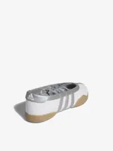 Zapatillas Adidas Taekwondo Mei Ballet, color blanco con detalles plateados y suela color caramelo. Diseño inspirado en las bailarinas, con tres tiras elásticas de diferentes largos para atar de múltiples formas.