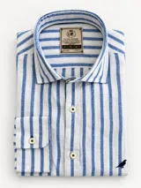 Camisa Club House de manga larga y corte clásico, confeccionada en 100% lino color azul con diseño de rayas finas verticales blancas. Presenta cuello corto, cierre frontal con botones blancos y detalle de bordado de un pájaro en el pecho.