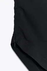 Top strapless de color negro con escote recto, detalle de pliegues en la parte superior y bajo asimétrico en punta.