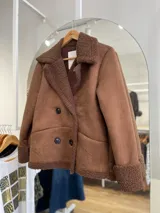 Chaqueta negra con forro tipo corderito, doble botonadura y cuello solapa.