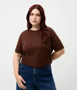 Remera de malla color tostado con cuello redondo, mangas cortas y aplicación de strass salpicado en toda la prenda.