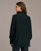 Camisa azul con mangas largas abullonadas, cuello italiano y corte entallado.