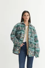 Sobrecamisa de franela gruesa con estampado geométrico en tonos verde, gris, rosa y celeste. Tiene cuello solapa clásico, bolsillos cuadrados en el pecho, botones personalizados y calce holgado.