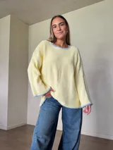 Sweater de punto jersey de algodón color amarillo con silueta oversize, mangas acampanadas y cuello a la base. Presenta terminaciones hechas a mano en crochet a contratono en color celeste con detalles de lurex.