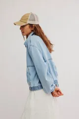 Campera bomber oversize de denim suave, color azul claro con efecto gastado, cierre frontal metálico y elástico en puños y cintura.