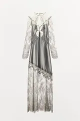 Vestido largo de satén y encaje color gris, con cuello redondo, manga larga y cierre en la espalda con abertura y botón.