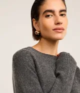 Suéter gris melange de punto con cuello redondo y manga larga.