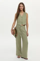 Pantalón de lino color beige, de corte ancho y relajado, con cintura alta y bolsillos laterales.