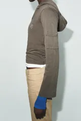 Sudadera de algodón color gris oscuro con capucha, manga larga y detalle de texto con aplicación de brillos en el pecho. Presenta un diseño con bolsillos laterales en las mangas y bajo recto.