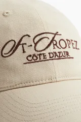Gorra de sarga color beige con bordado marrón de la frase "St-Tropez Cote D'Azur".